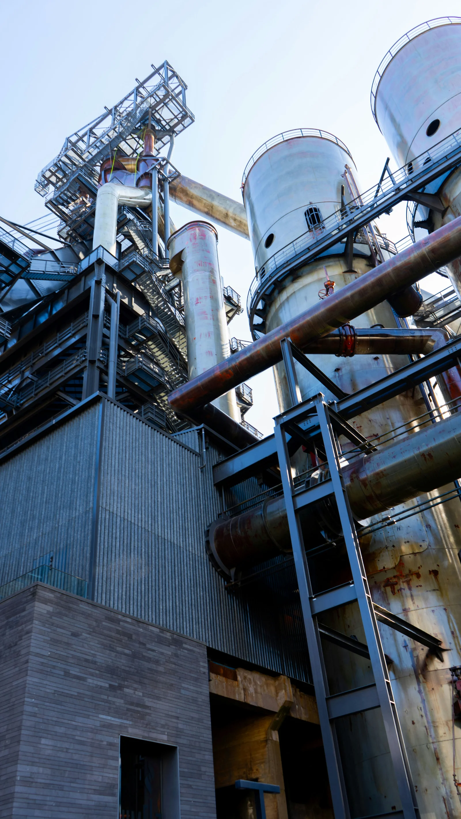 Tall processing vessels, steel platforms and pipework viewed from ground level
