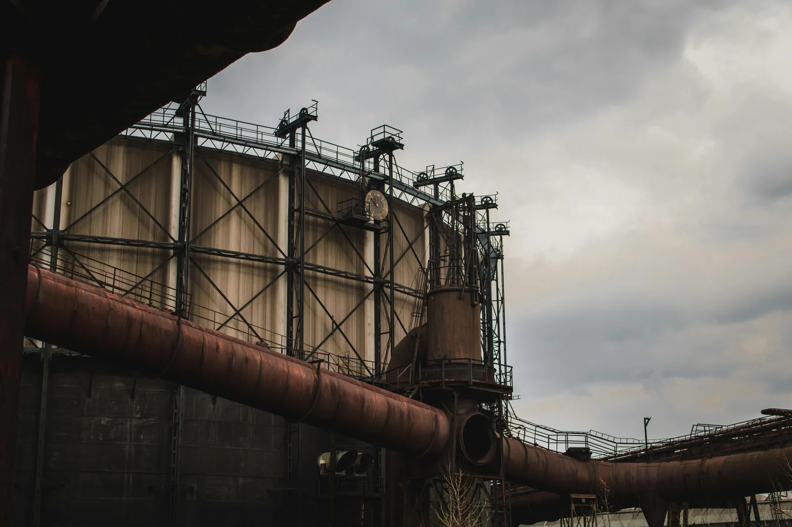 An ageing industrial tank with external pipework and access platforms